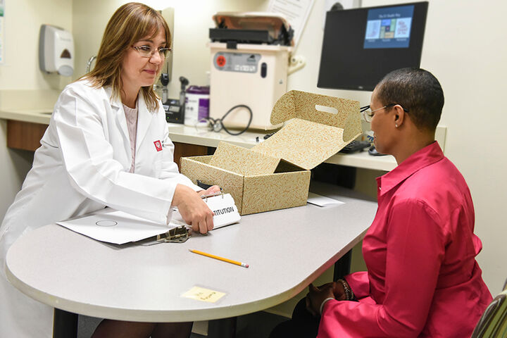 A physician working with a patient at a table